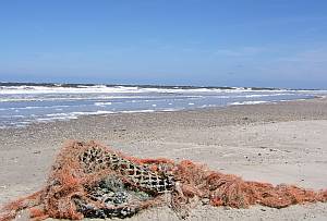 Ein zerrissenes Netz kündet am Strand vom Fischfang.